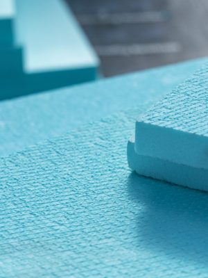 Close-up of turquoise blue foam blocks with textured surfaces, stacked diagonally in the background.
